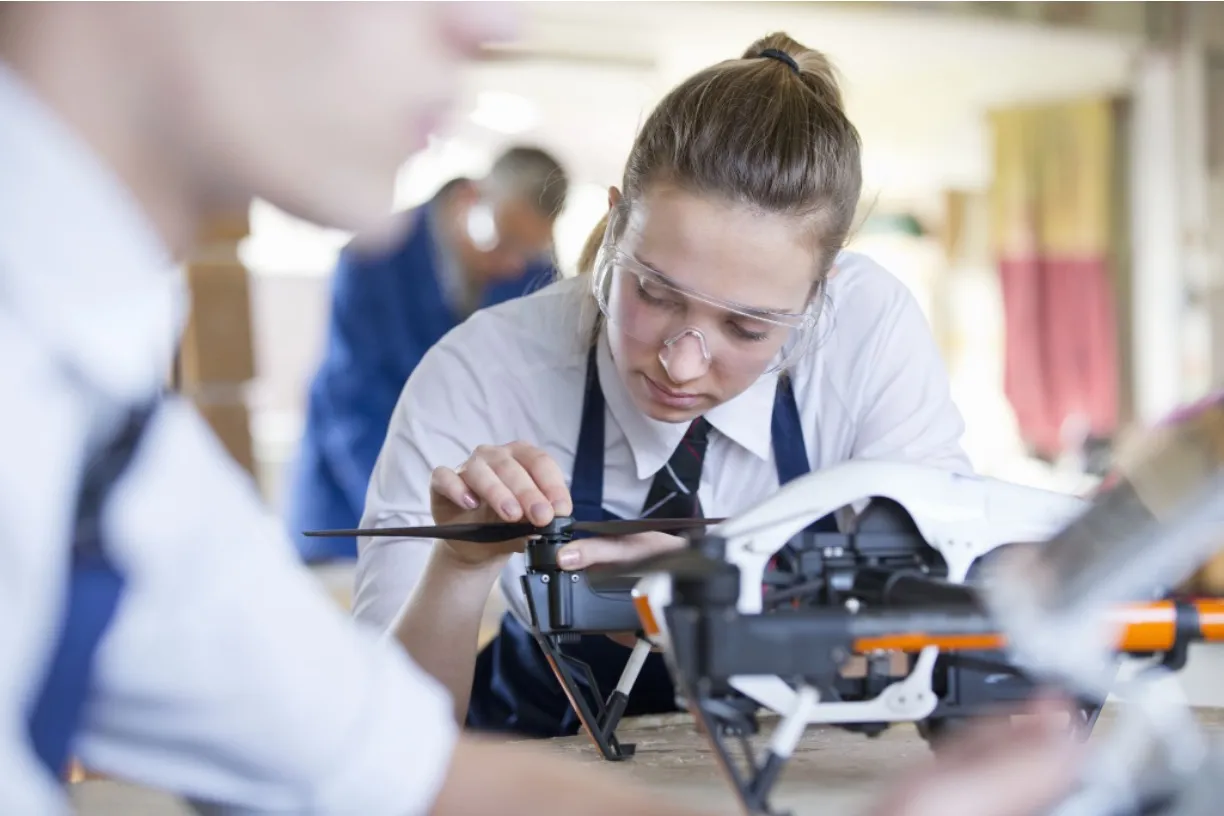 Technicians assembling a drone at a workbench